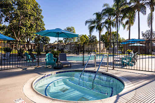A pool with a slide and a fence.