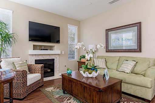 A living room with a fireplace, a couch, a chair, a coffee table, and a television.