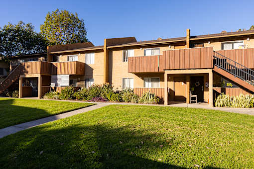A large apartment complex with a green lawn in front.