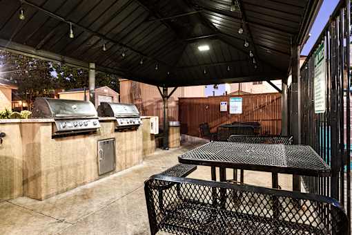 A patio with a table and chairs under a roof.