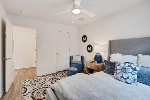 A bedroom with a bed, a chair, and a rug.