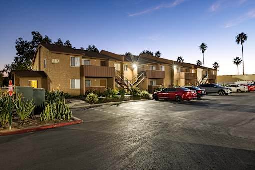A parking lot with cars and apartment buildings in the background.