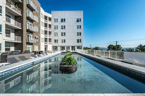 a water feature with an apartment building in the background