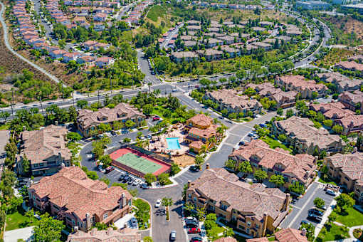 A bird's eye view of a residential area with houses and a pool.