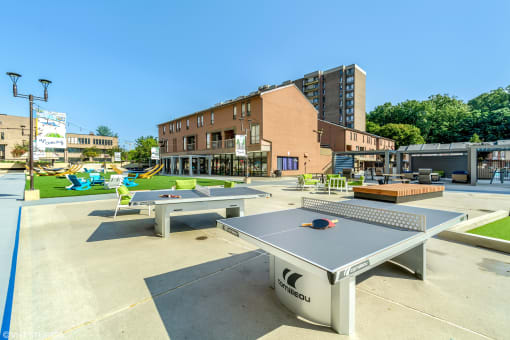 a ping pong table and lounge area are located in the middle of the courtyard