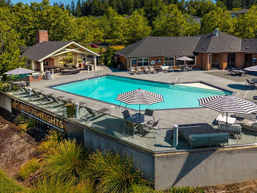 A large outdoor swimming pool with loungers and umbrellas.