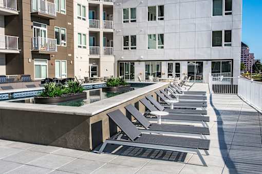 a water feature with lounge chairs in front of a building