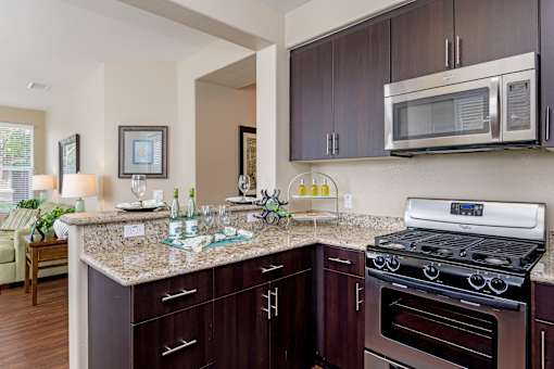 A kitchen with brown cabinets and a granite countertop.