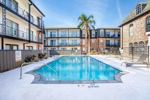 A pool with buildings surrounding it.