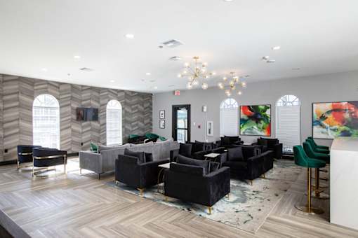 A large room with a chandelier, couches, and a bar.