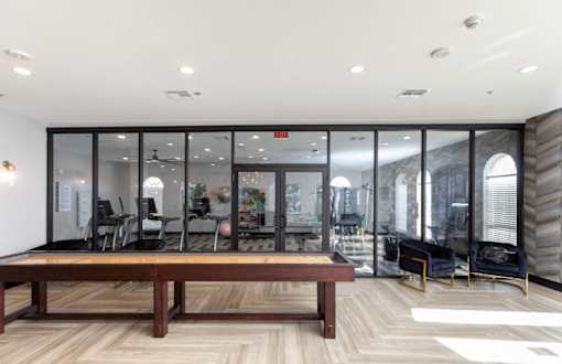 Resident lounge with a long wooden table and black chairs.