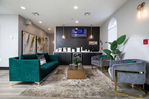 Leasing office with a green velvet sofa and a coffee table in the center.