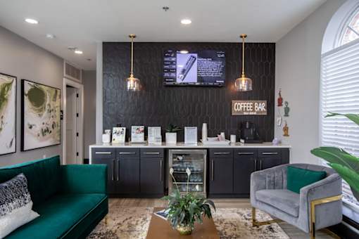 Leasing office with a green sofa and a coffee bar.