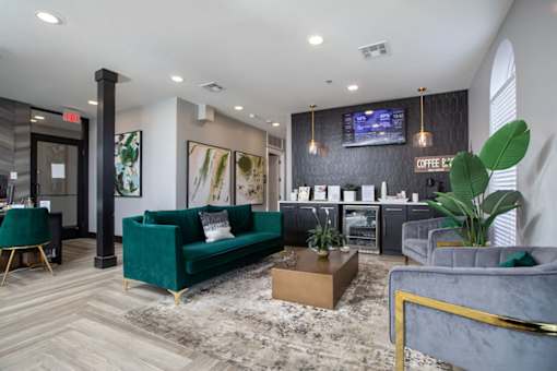 Leasing office with a green couch and a grey armchair.