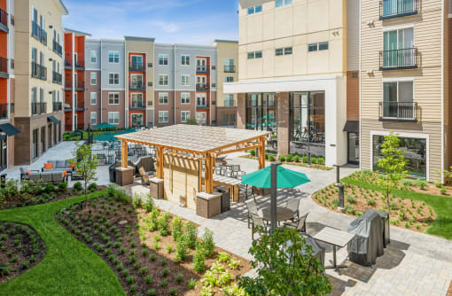 an outdoor patio area with tables and umbrellas in an apartment building
