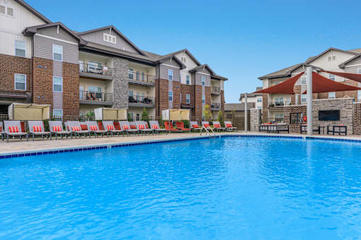 A large swimming pool in front of apartment buildings.