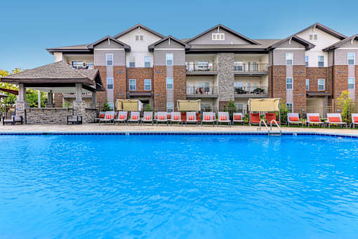 A large swimming pool in front of apartment buildings.