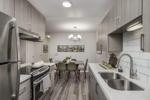Galley kitchen with stainless steel appliances and dining space at Canyon Creek Apartments, Oregon