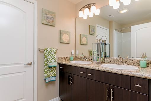 A bathroom with brown cabinets and a white door.
