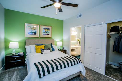 A bedroom with a bed, nightstands, and a ceiling fan.