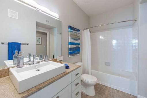 A white bathroom with a white sink and toilet.