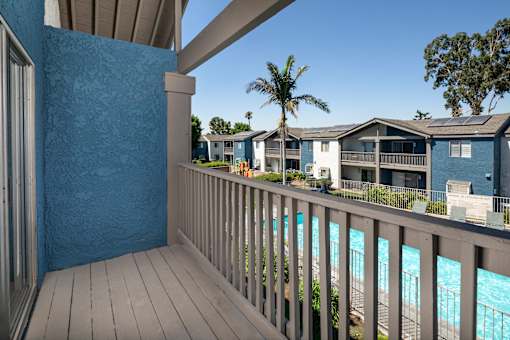 A balcony with a view of a pool.