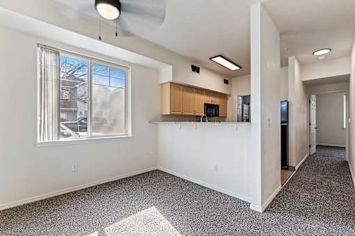 A room with a ceiling fan and a window with blinds.