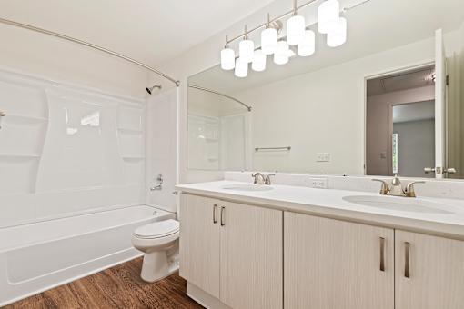 A white bathroom with a toilet, sink, and tub.