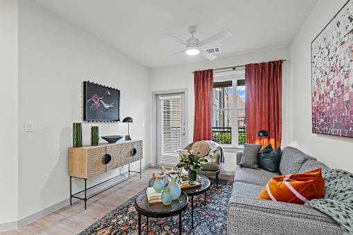 A living room with a grey couch, a coffee table, and a painting on the wall.