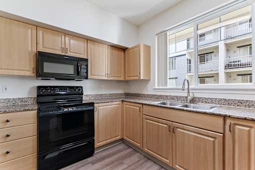 A kitchen with wooden cabinets and black appliances.