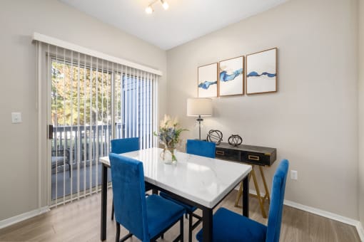 a dining room with a white table and blue chairs