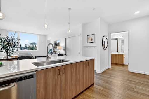 A modern kitchen with wooden cabinets and a large window.