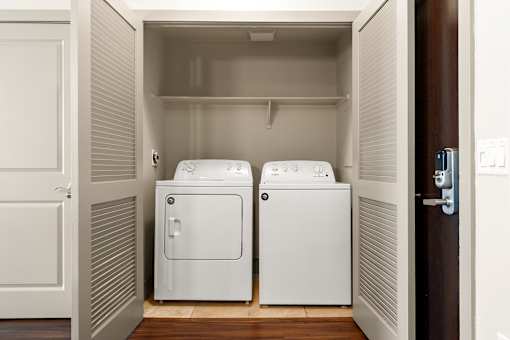 Two white washing machines in a small laundry room.