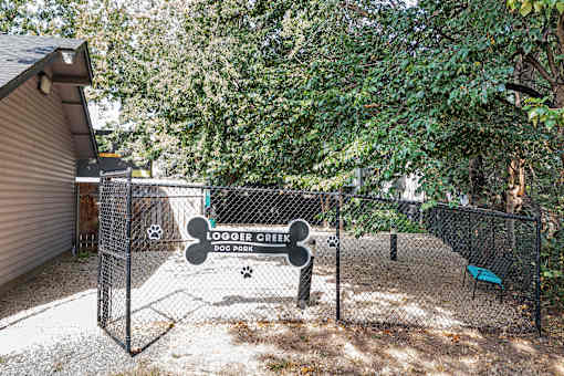 A dog park with a sign that says "Logger Creek Dog Park".