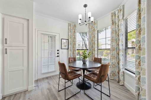 A dining room with a round table and chairs.