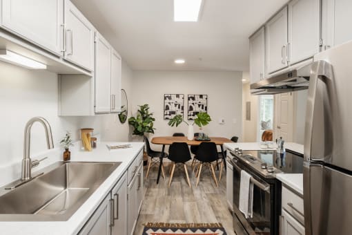 White galley kitchen with dining table and modern chairs at Canyon Creek Apartments, Wilsonville, 97070