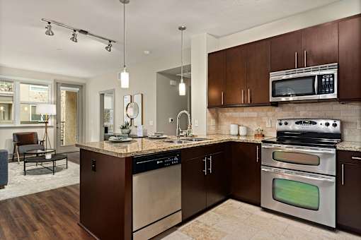 A modern kitchen with dark brown cabinets and stainless steel appliances.