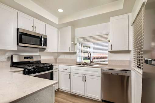 A kitchen with white cabinets and appliances.