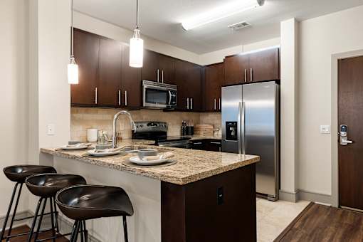 A kitchen with brown cabinets and a granite countertop.