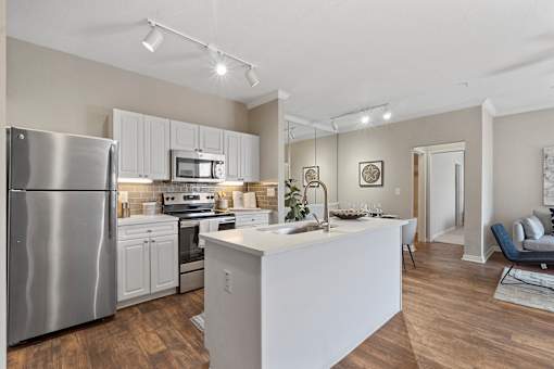 A modern kitchen with stainless steel appliances and wooden floors.