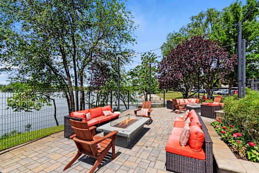 A patio with red couches and a fire pit.
