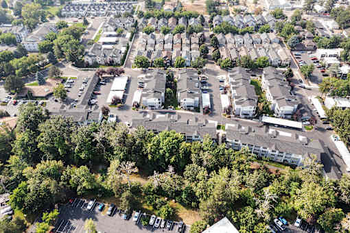 A bird's eye view of a residential area with houses and parked cars.
