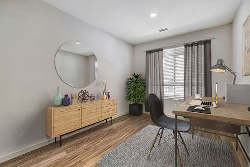 A room with a desk, chair, and a mirror on the wall.