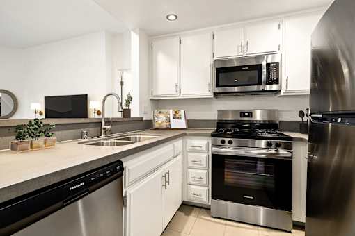 Modern kitchen with stainless steel appliances and white cabinets at Cahuenga Heights, Los Angeles, CA