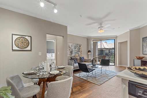 A dining room with a table set for four and a view of the backyard.