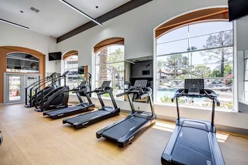 A gym with treadmills and a television.