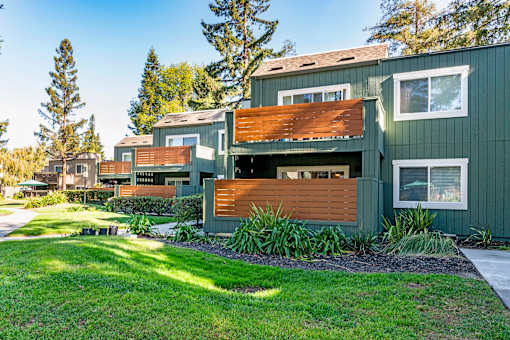 A green building with wooden slats on the windows and doors.