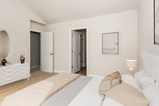 a bedroom with a white bedspread and a white dresser with a mirror