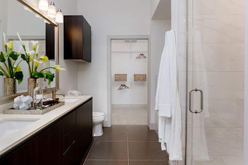 A bathroom with a white towel hanging on the door.