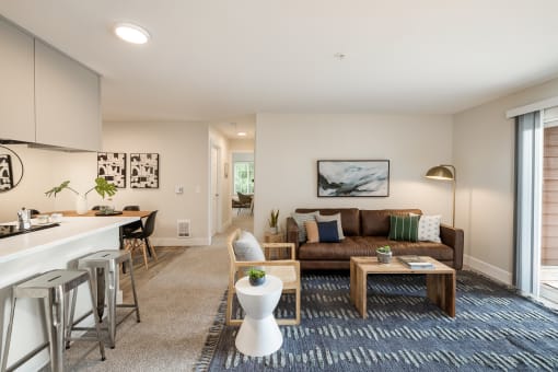 Open living room with brown leather sofa and dining bar at Canyon Creek Apartments, Oregon, 97070
